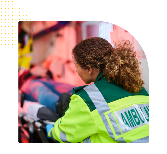EMS worker helping load patient in ambulance